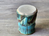 Rustic artisan mug on timber background showing the base.