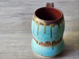 Close-up of wheel-thrown turquoise stoneware mug