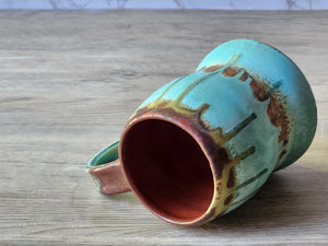 Rustic turquoise mug on timber background