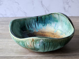 Wheel‑thrown and altered pottery bowl in mottled green and brown tones