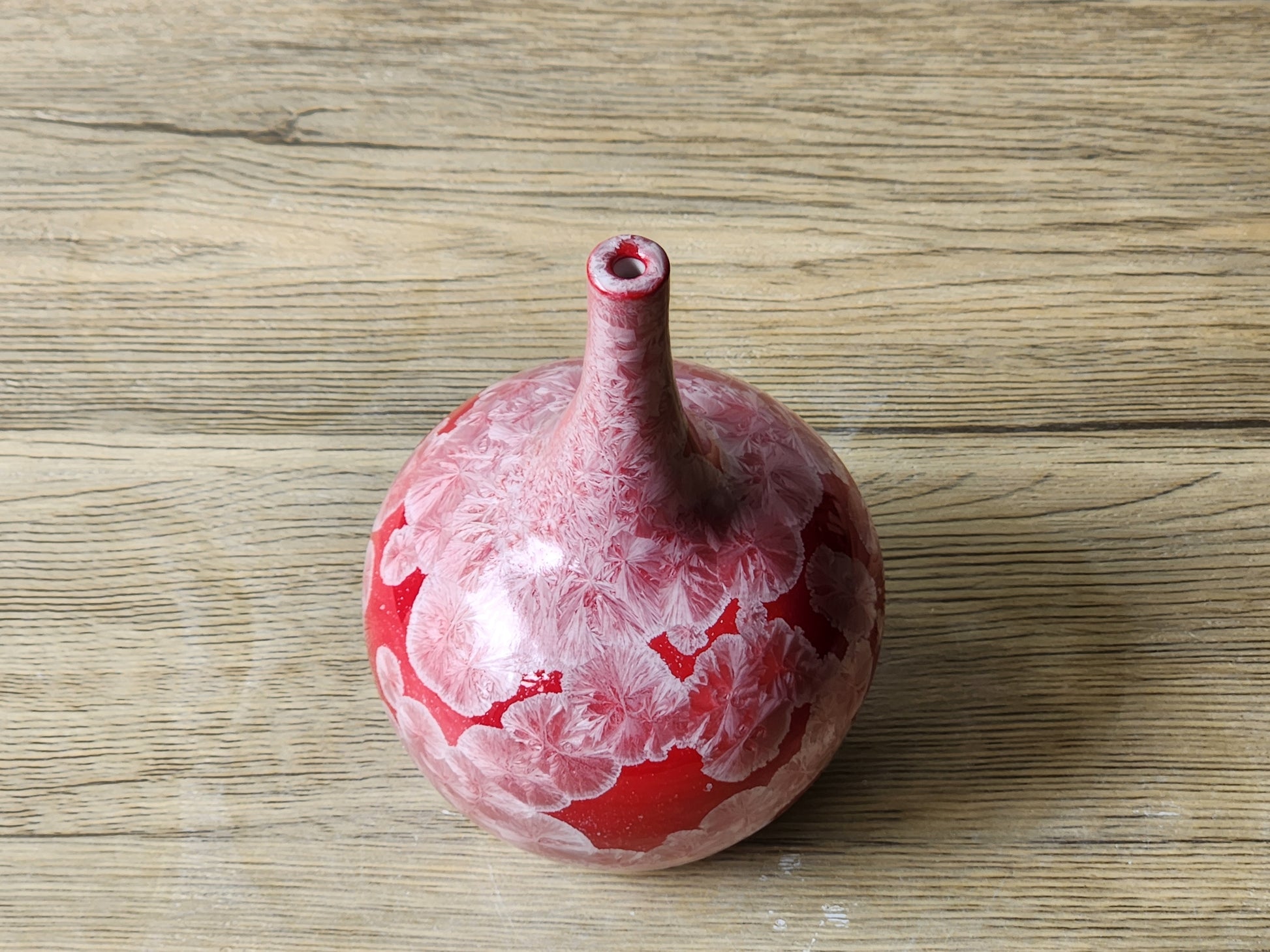 Glossy red ceramic vase with natural crystals