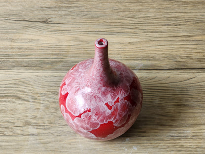 Glossy red ceramic vase with natural crystals
