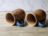 Durable stoneware mugs with organic glaze patterns and amber glazed interior.