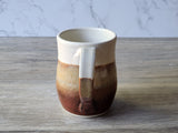 Back view of handmade pottery mug showing handle detail and glaze transition