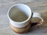 Close-up of handmade ceramic mug interior with speckled glaze, stoneware pottery