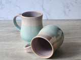 Handmade ceramic mug shown upright and on its side, green glazed stoneware pottery mug