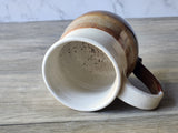 Extra large handmade ceramic mug on its side showing interior glaze, stoneware pottery
