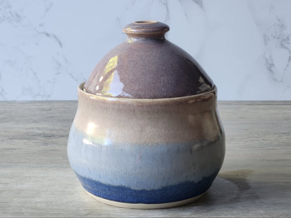 Handmade ceramic sugar bowl with fitted lid, blue and beige glaze, front view