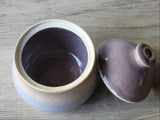 Handmade ceramic sugar bowl and lid displayed separately on kitchen bench