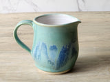 Wheel-thrown ceramic milk jug with pouring spout and curved handle