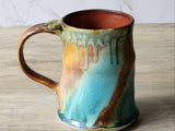Handcrafted ceramic mug showing organic glaze drips and curved handle