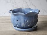 Handmade ceramic berry bowl with drainage holes on matching saucer, blue glazed pottery colander