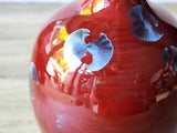 Close-up of blue crystal fan on red crystalline glaze ceramic vase surface detail