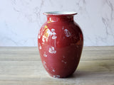 ) Side angle of glossy red porcelain vase with scattered silver crystal blooms, 17cm