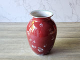 Three-quarter view of handmade red porcelain vase showing crystal pattern across the body