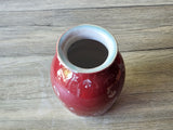 Three-quarter view of handmade red porcelain vase showing crystal pattern across the body made in melbourne.