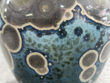 Macro detail of crystalline “galaxy” glaze with star-like specks and crackle pattern on handmade ceramic vase