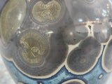 Close-up detail of galaxy crystal glaze pattern resembling a night sky on handcrafted ceramic vase