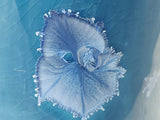 Macro shot of pale crystal bloom pattern on handmade blue bud vase glaze