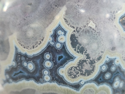 Close up of deep galaxy crystalline glaze with star-like crystal blooms on handmade ceramic vase