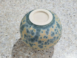 Base view of handmade ceramic vase showing Buxton Pottery stamp and teal crystalline glaze over cream matte background