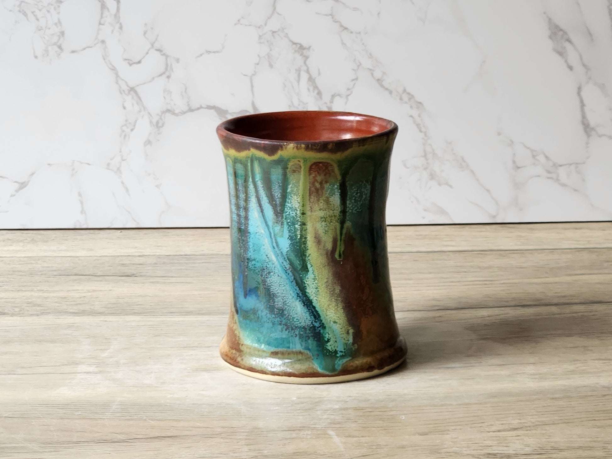Artisan ceramic mug with layered green blue and brown glaze