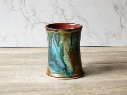 Artisan ceramic mug with layered green blue and brown glaze