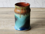 Close-up of handmade mug showing layered glaze colours and speckled texture