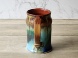 Rustic handmade pottery mug on wooden surface in kitchen lifestyle setting