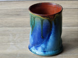 Pottery coffee mug with organic shape, green glaze drips and earthy tones