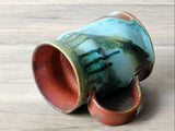 Stoneware mug with ocean green glaze and dark drip pattern, handmade in Australia