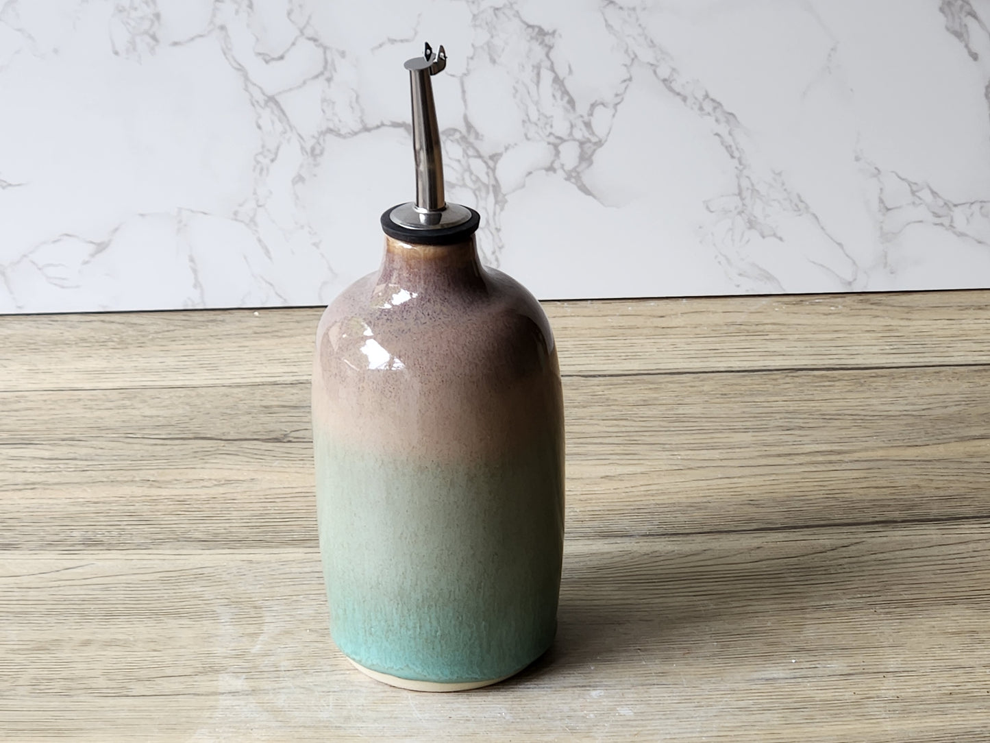 Handmade pottery oil cruet in green and brown tones, artisan ceramic kitchen bottle