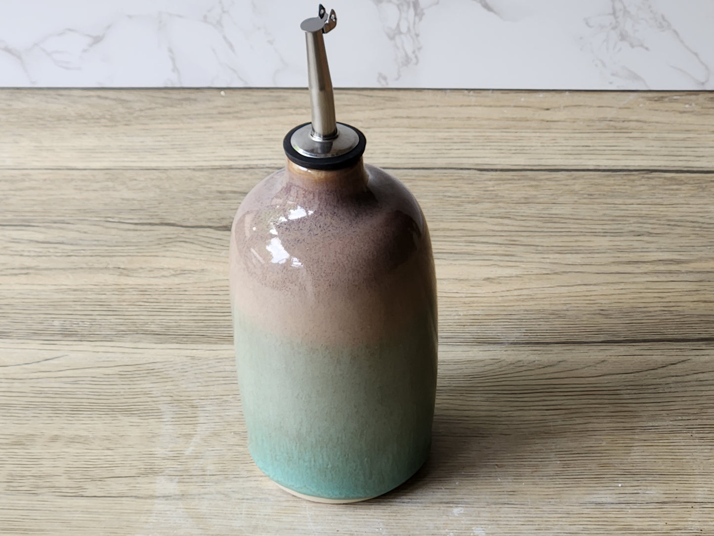 Ceramic olive oil bottle with green glaze and brown accents, handmade in Melbourne Australia