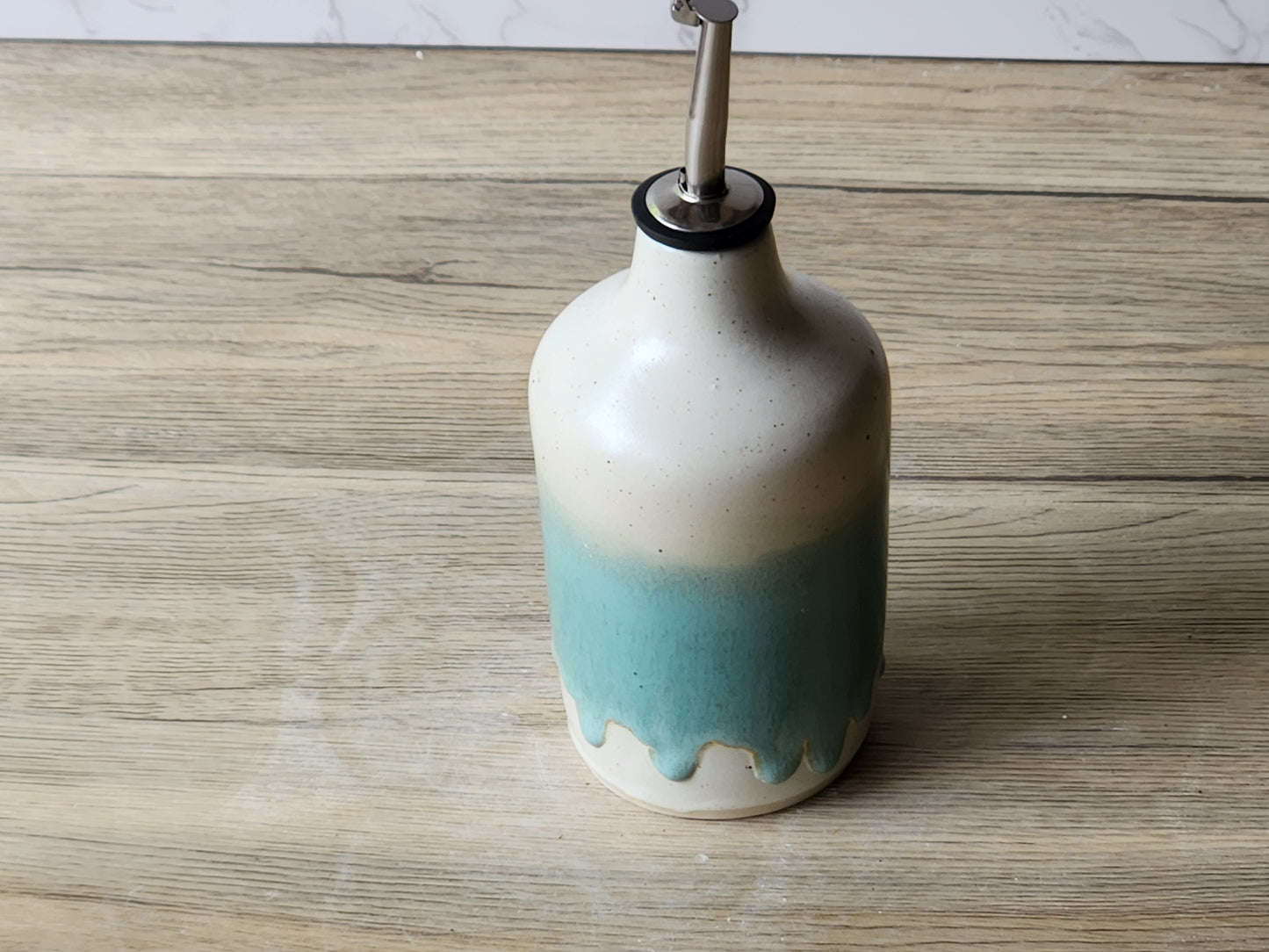 Handmade pottery oil cruet with drip glaze detail and metal pourer