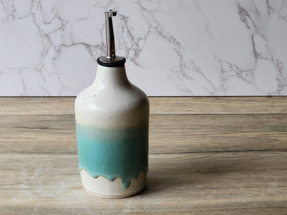 Handmade ceramic olive oil dispenser with pour spout on kitchen bench