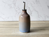 Handmade stoneware oil bottle in warm brown and cream ombré glaze