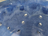 Close-up of glossy blue speckled glaze on handmade ceramic berry bowl