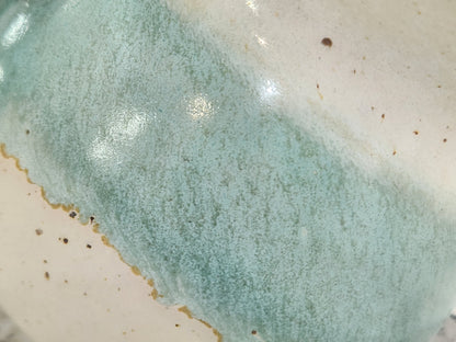 Close-up of aqua and cream glaze on a handmade ceramic salt pig
