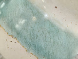 Close-up of aqua and cream glaze on a handmade ceramic salt pig