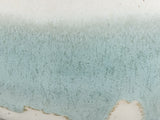 Close-up of speckled cream and soft green glaze on a handmade ceramic sugar bowl