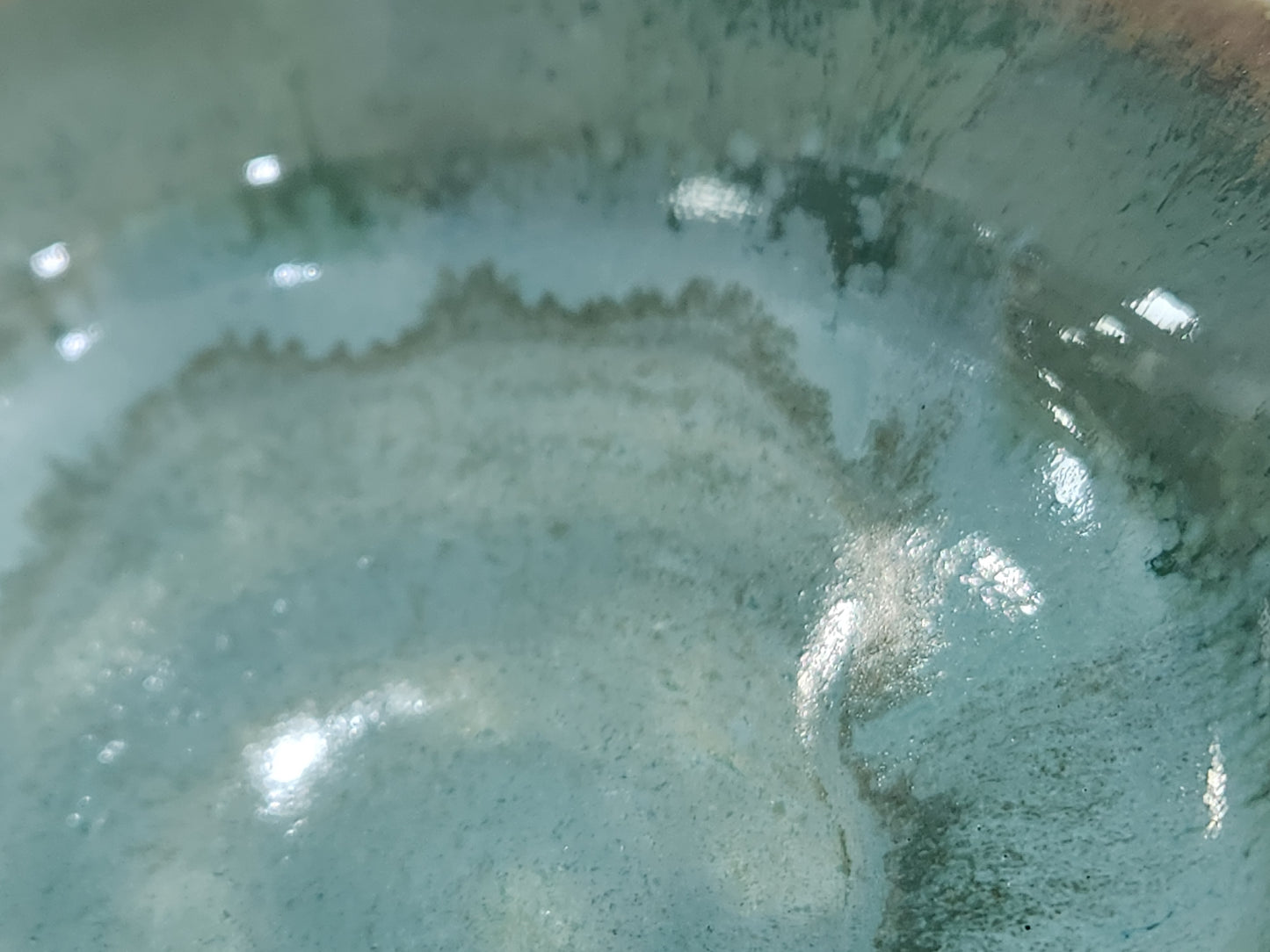 close up of crystalline style glaze handmade ceramic bowl green tones