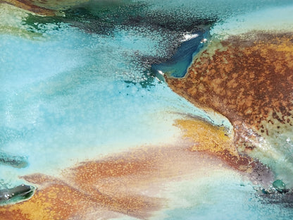 Close-up of handmade pottery mug showing turquoise, terracotta, green and deep earthy glaze movement