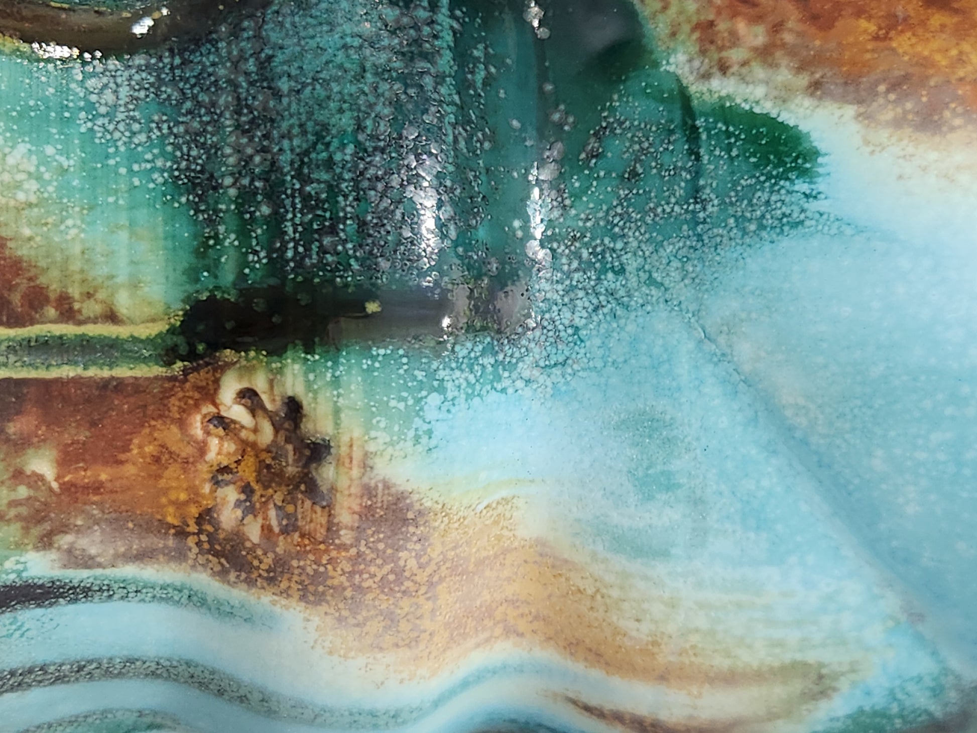 Close-up of handmade pottery mug showing turquoise, terracotta, green and deep earthy Bush Creek glaze movement