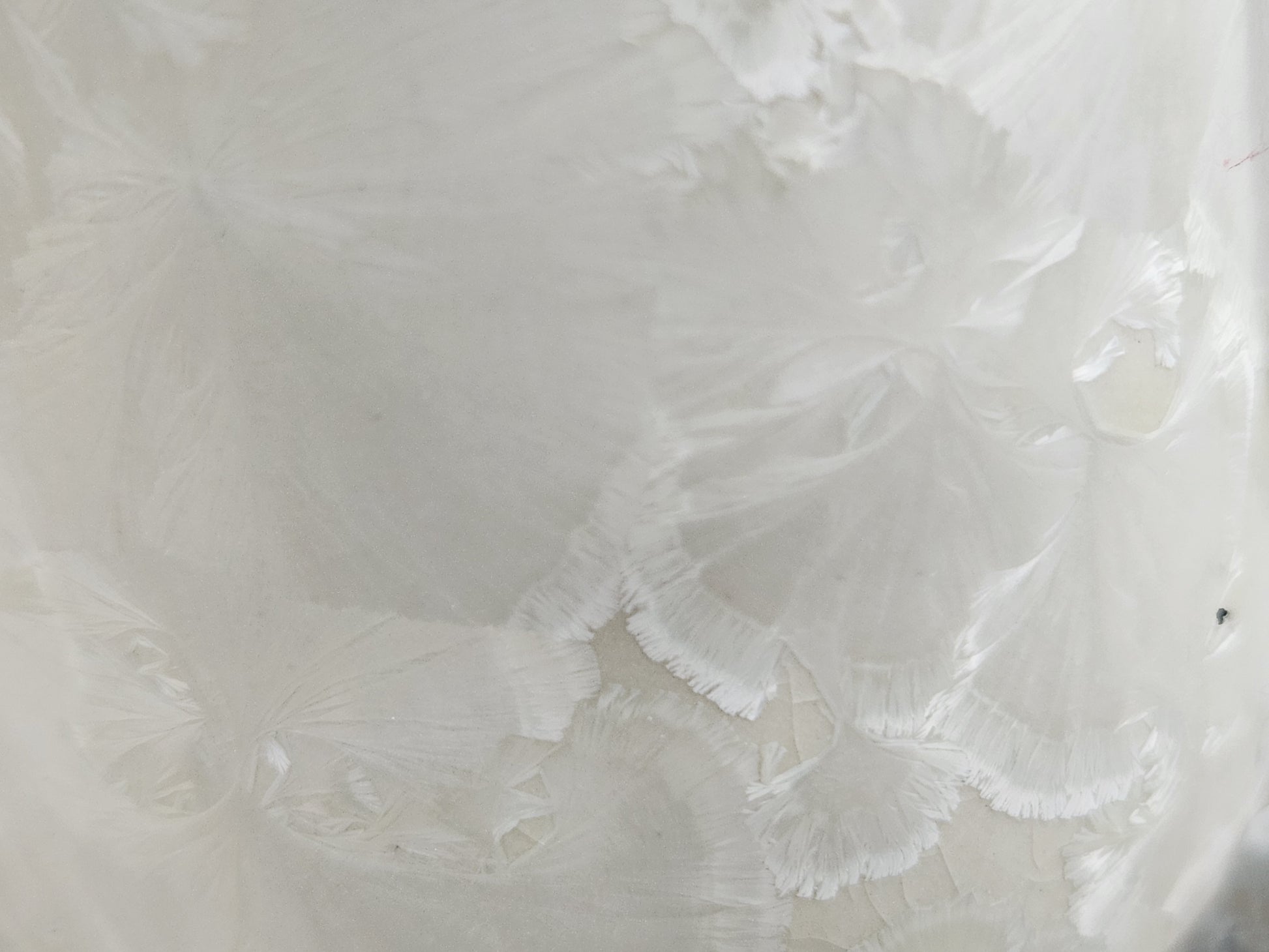 Close-up of delicate crystal patterns on a white porcelain mug