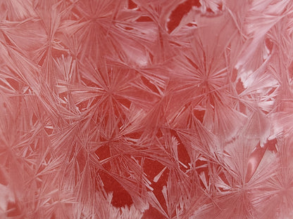 Close-up of pale crystal patterns over a rich red porcelain glaze