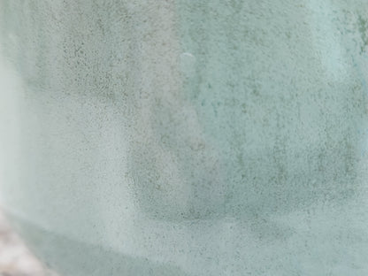 Close-up of handmade pottery sugar bowl showing soft seafoam green glaze and glossy surface variation