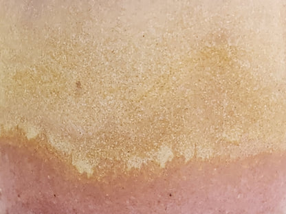 Close-up of soft pink and creamy oatmeal glaze on handmade stoneware mug