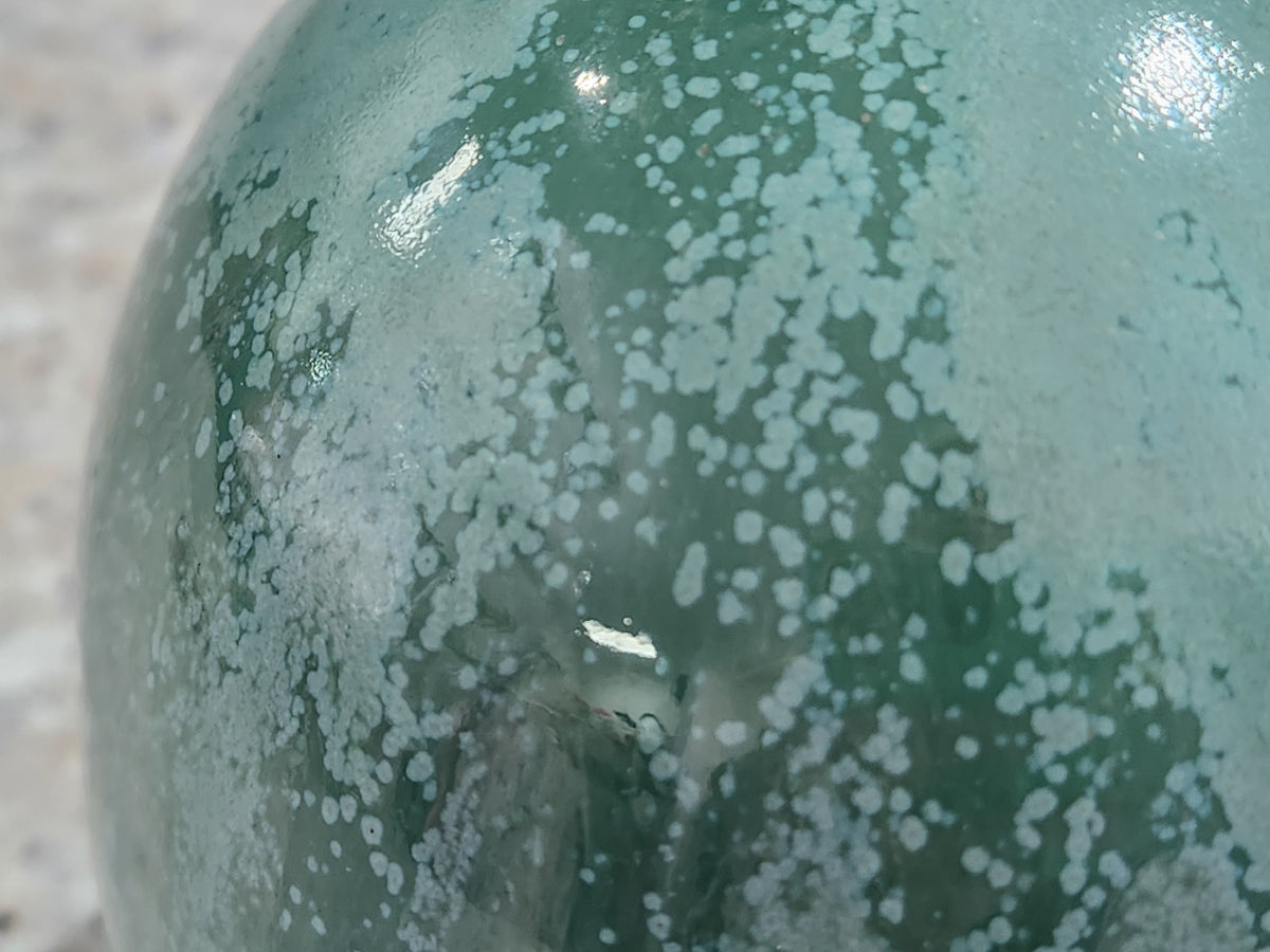 Close-up of organic mottled green glaze on handmade stoneware salt pig