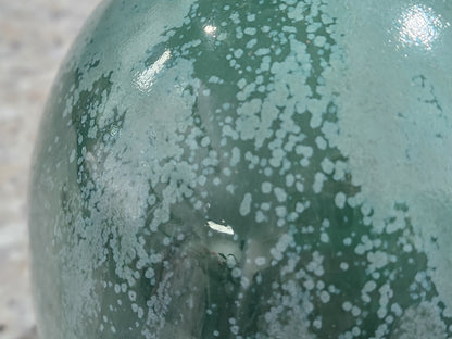 Close-up of organic mottled green glaze on handmade stoneware salt pig