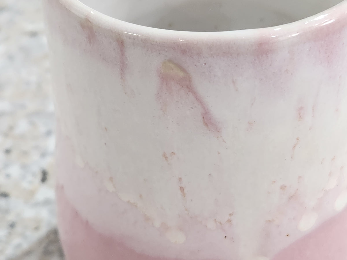 Close-up of soft pink and creamy white glaze on handmade ceramic mug